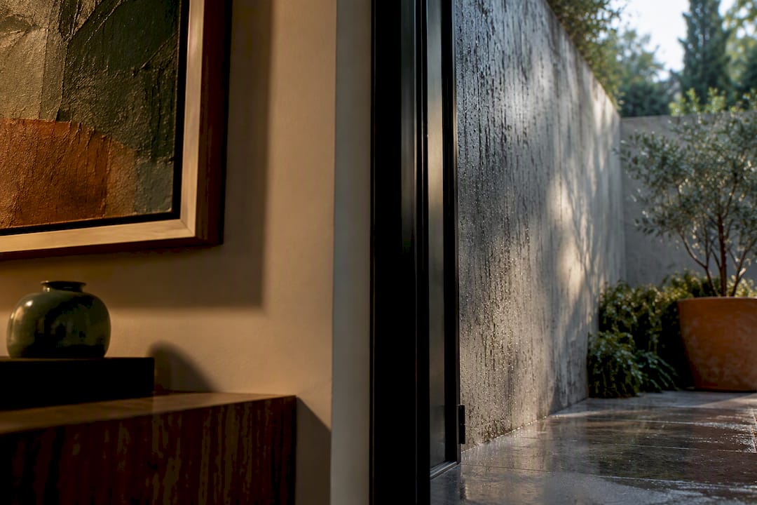 Indoor artwork beside weather-exposed exterior wall