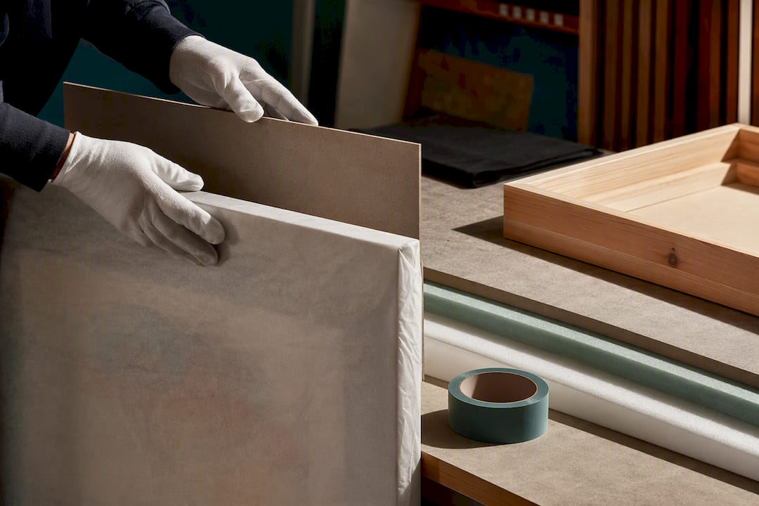 Rigid backing protecting a wrapped large canvas